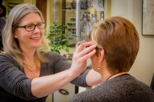 Optician fitting a patient with frames